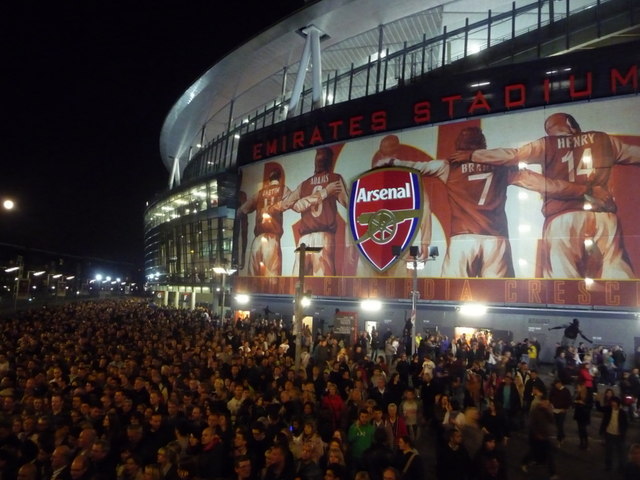 Hinchas siguiendo partidos y cuotas en una noche de fútbol